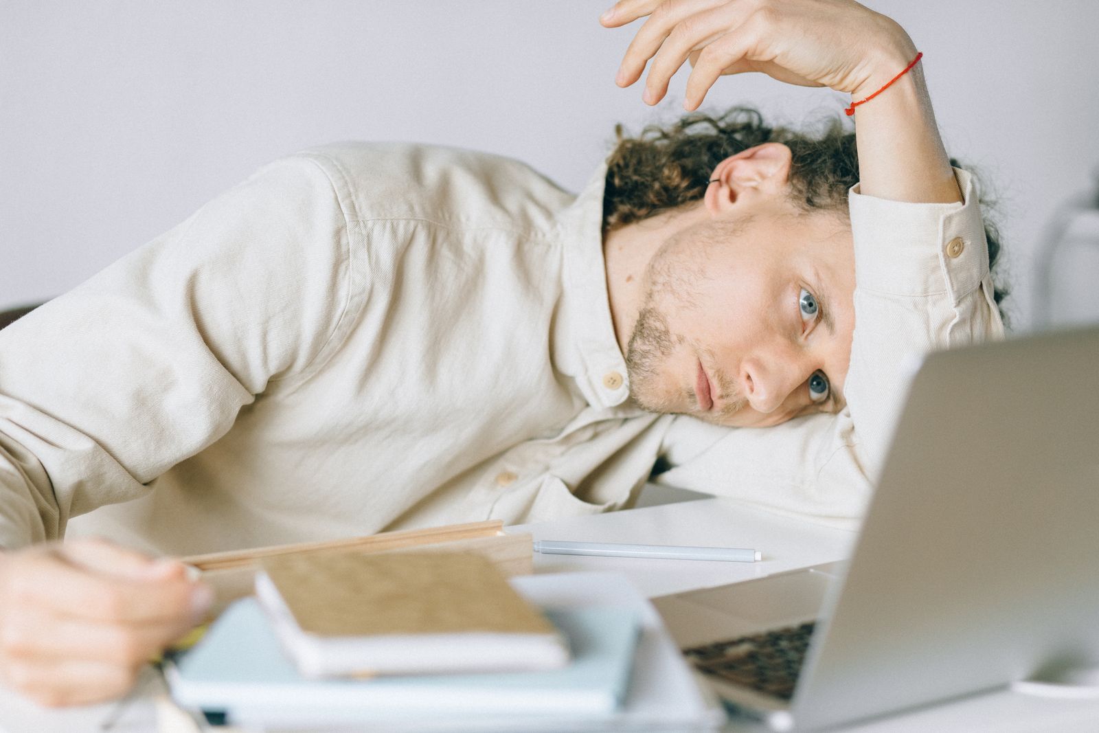 日中に強い眠気で机に伏せる人